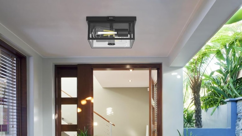 A light with a glass enclosure mounted on a white ceiling