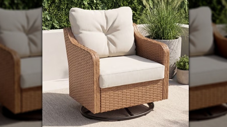 A beige and cream outdoor swivel chair on a patio