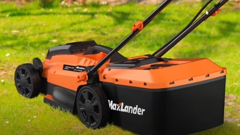 An orange and black lawn mower in a yard