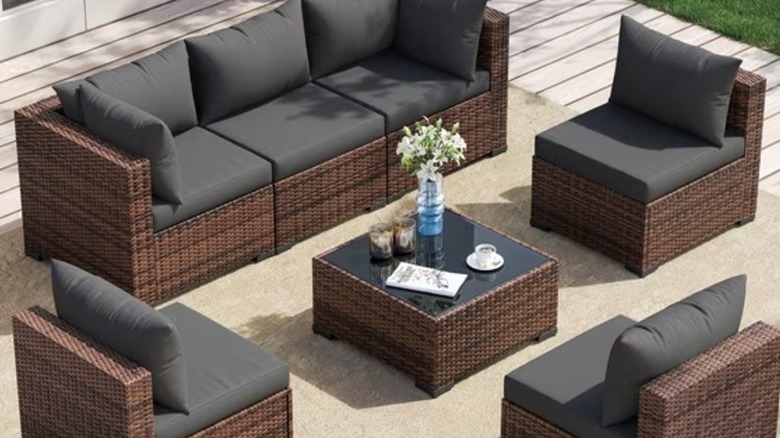 A black and brown outdoor sofa set on a patio