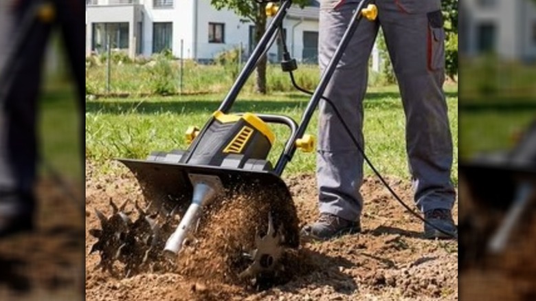 Man using a garden tiller in a home's yard