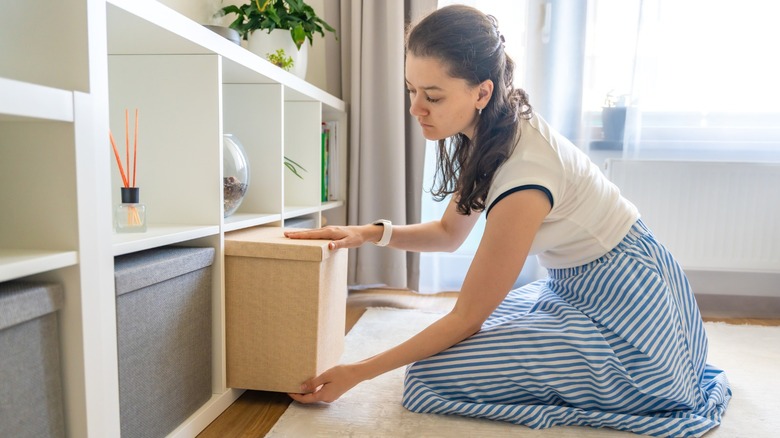 Woman organizing storage boxes on a shelf