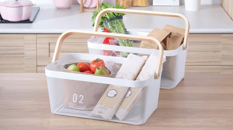 Fresh vegetables are stored in two mesh baskets on a kitchen countertop