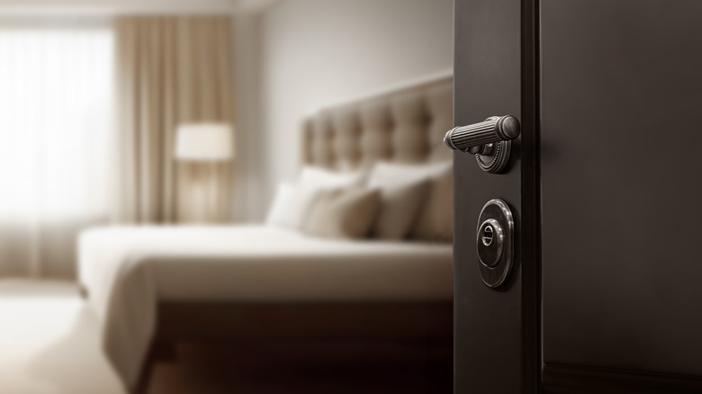 a black door opens into a bedroom