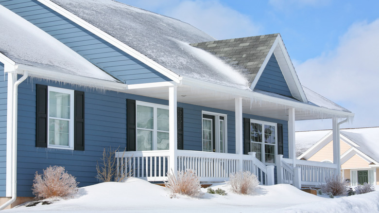 blue house covered in ice and snow
