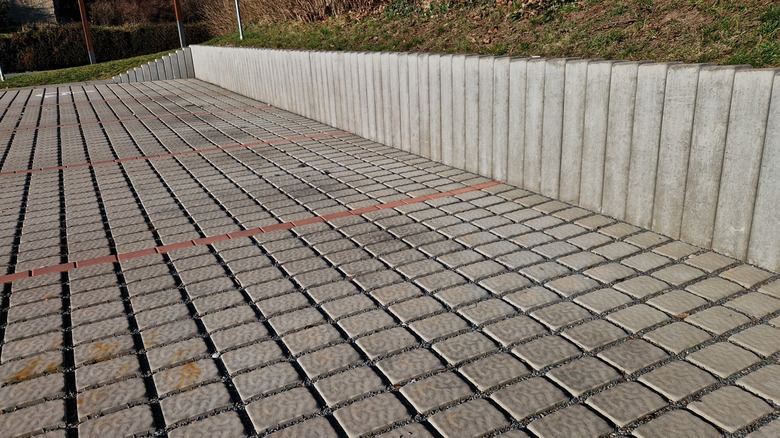 Close up of a pervious paver driveway, laid in a grid with joints filled with smaller rock.