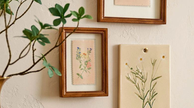 A floral print in a wooden frame hangs on a gallery wall