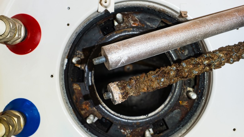 New and used magnesium anode rods on top of a water heater