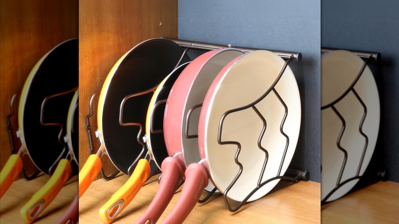 Colorful pans laid horizontally in a tiered shelving unit