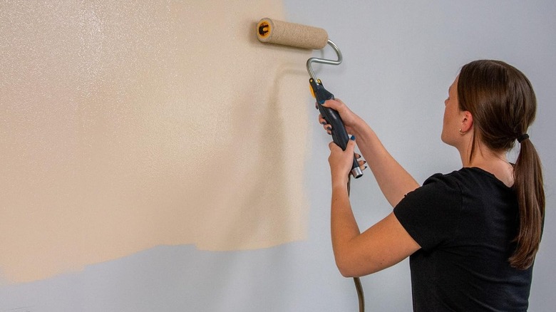 Woman using Wagner PowerFlow EZ Roller to paint wall
