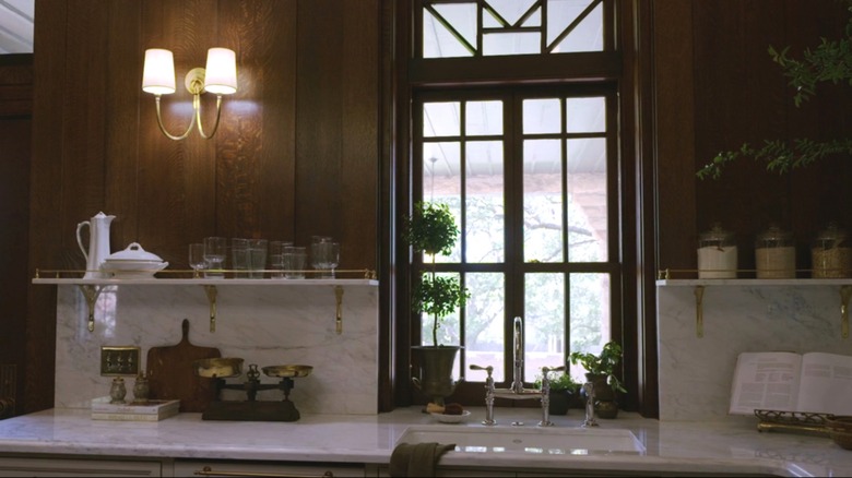 Marble backsplash and countertops in dark, historic kitchen
