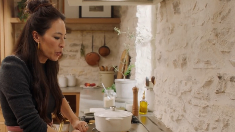 Joanna Gaines in front of whitewashed exposed brick backsplash