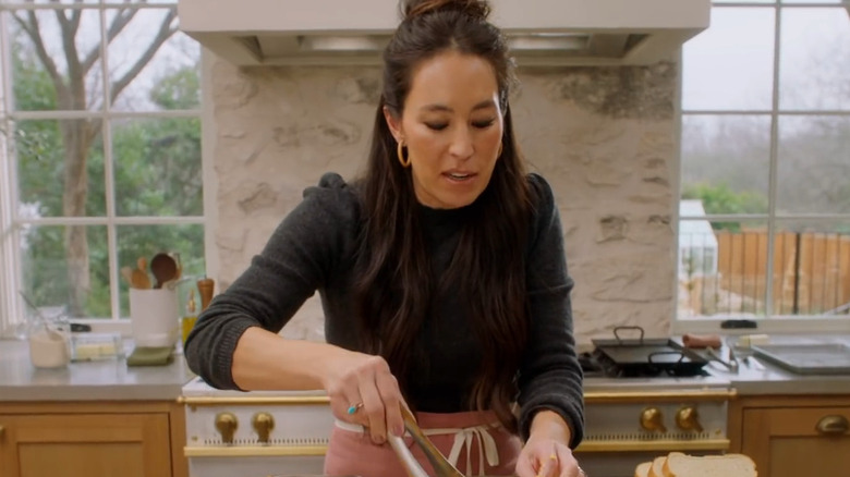Joanna Gaines in front of whitewashed exposed brick backsplash