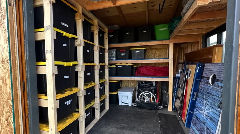 custom-built shelving unit with lots of plastic bins on the shelves and railings