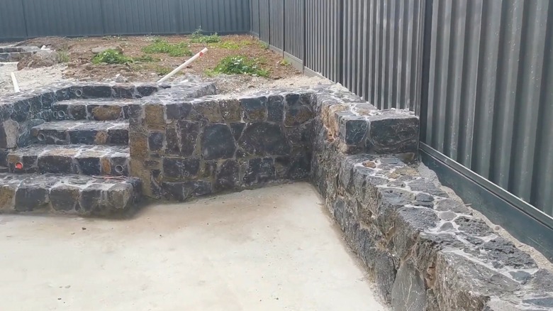 A basalt stone retaining wall with stairs in the middle