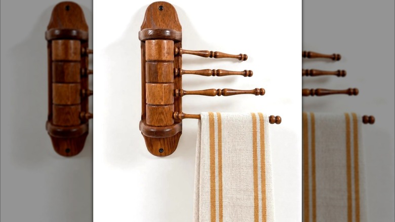 A vintage swivel towel rack holding a striped towel