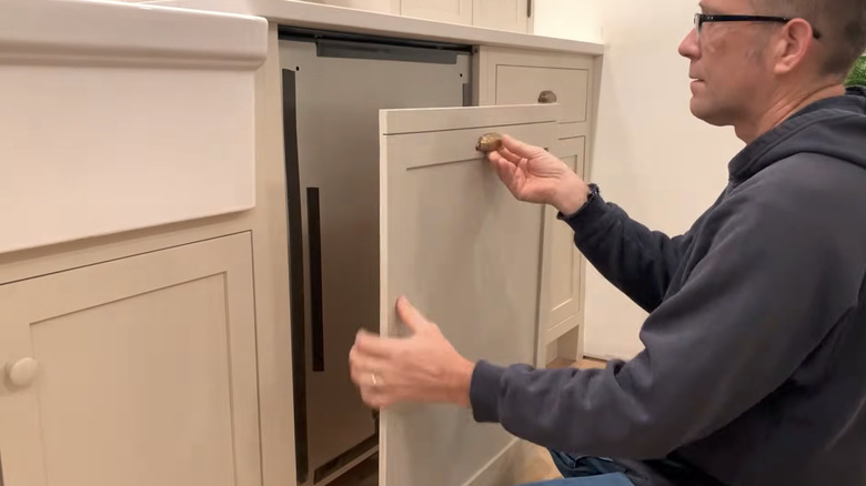 Person installing panel on dishwasher