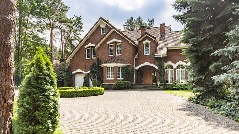 a cobbled driveway in front of a mansion