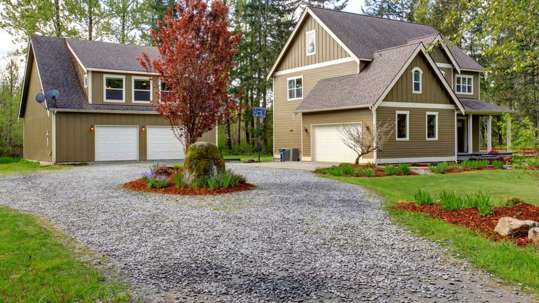 Modern home with accessory garage and gravel turnaround driveway