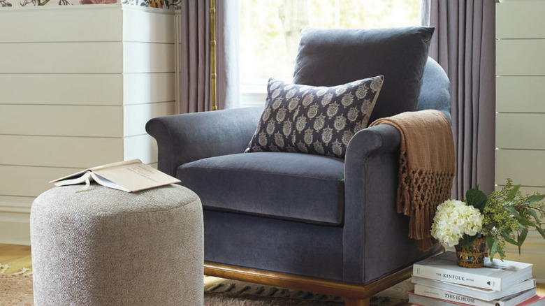a Stickley armchair and Gumdrop stool next to a pile of books with flowers.