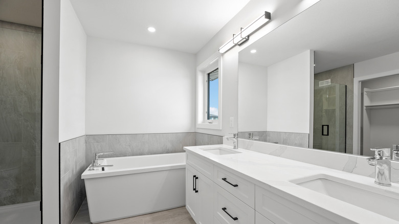 Plain white bathroom with a frameless mirror