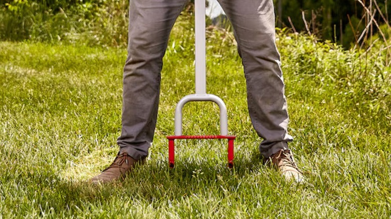 Person using Corona Lawn Aerator on their lawn.