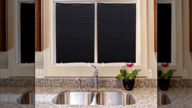 Pleated temporary blackout window shades above a kitchen sink