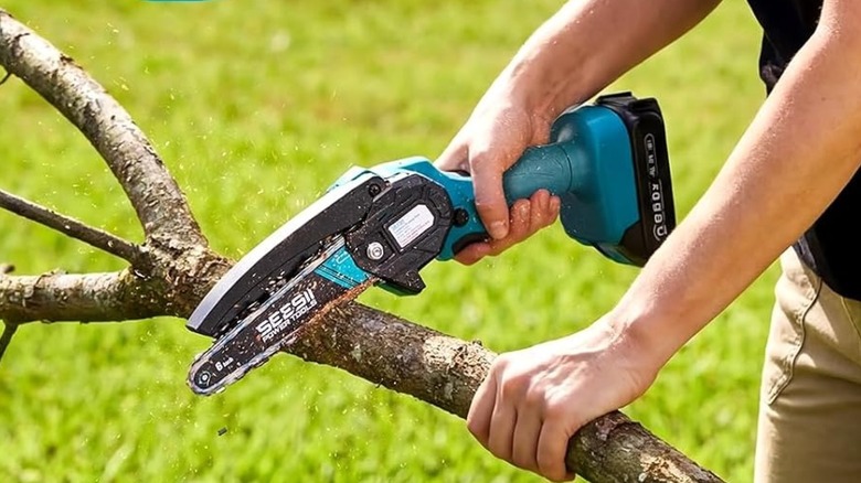 Person using Seesii Mini Chainsaw on tree branch