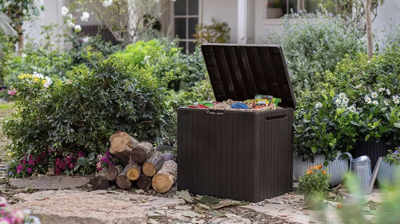 Brown deck box with a raised lid in a garden