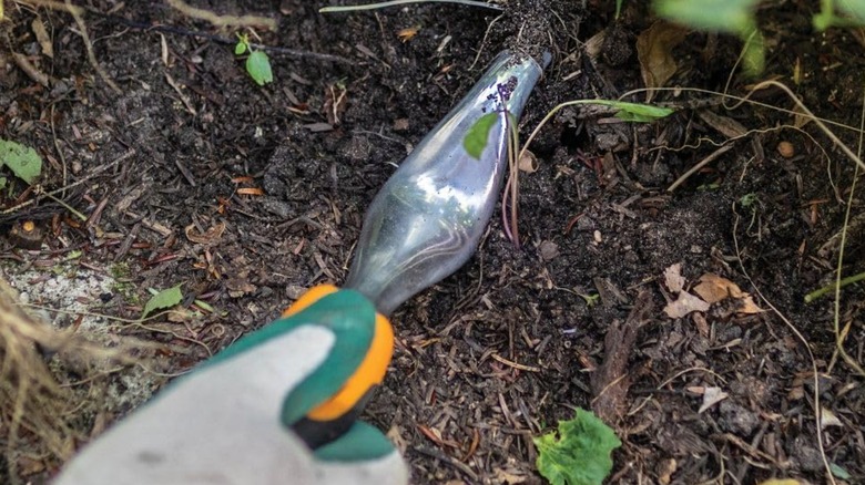 Person using the Fiskar Hand Weeder Tool.