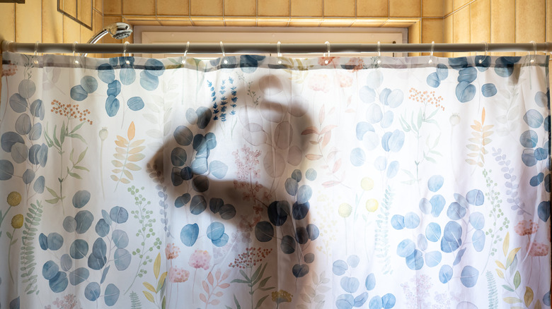 A man behind a shower curtain