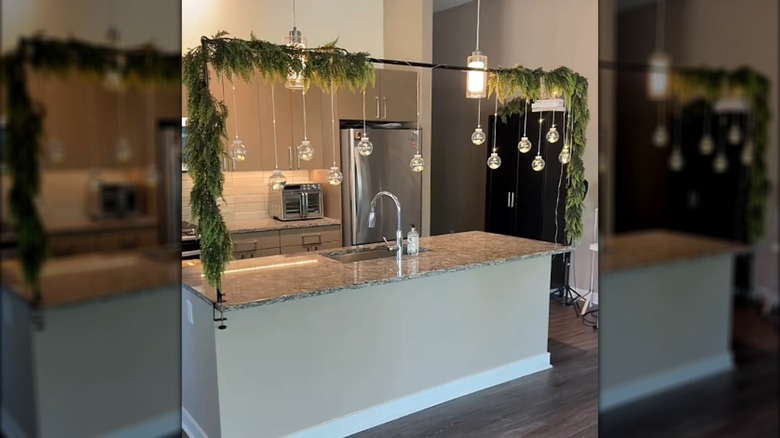 Kitchen island decorated with an over-the-table rod stand featuring pine boughs and ornaments