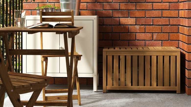 NÄMMARÖ storage box sitting on a patio near a dining table set and another storage cabinet