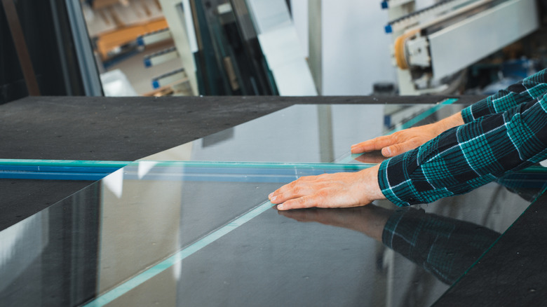 A man preparing to cut a glass panel