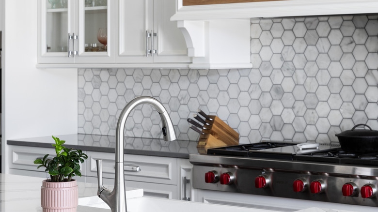 a modern kitchen with a gray tile backsplash
