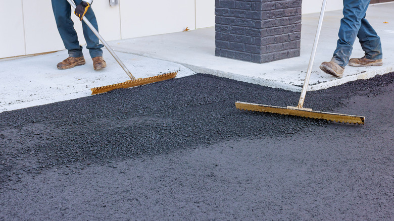 Workers spreading fresh asphalt