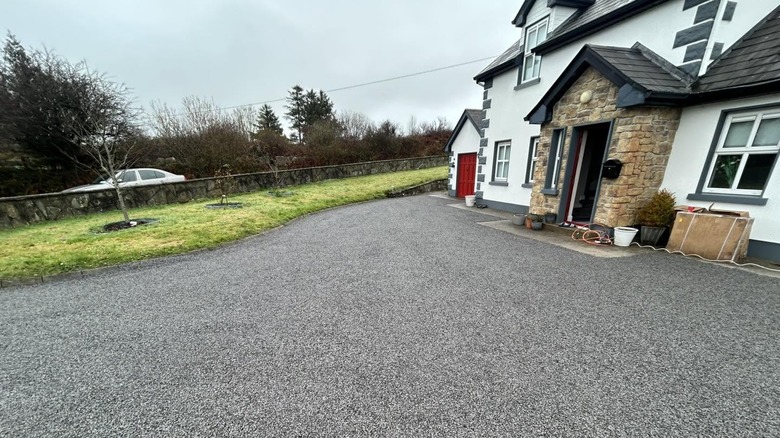 A tar-and-chip driveway in front of a home