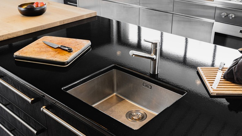 A black lava stone kitchen island with a sink