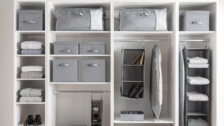 A white modular wardrobe with gray storage bins inside