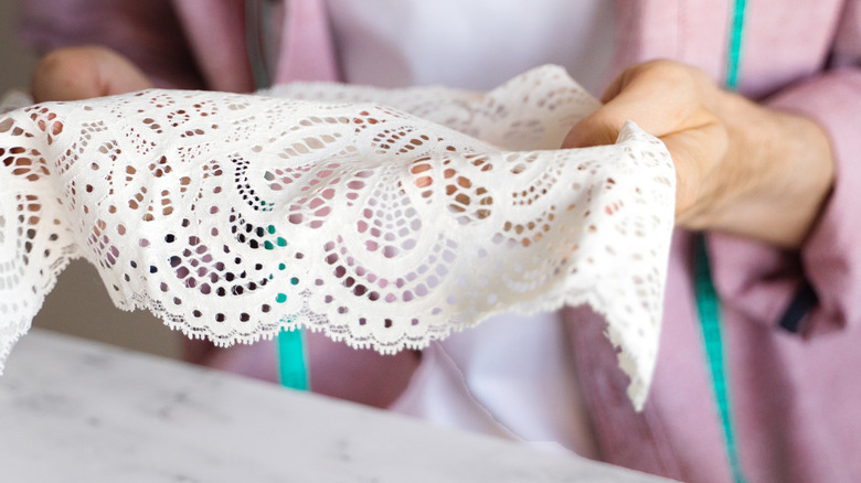 A man holds a vintage doily
