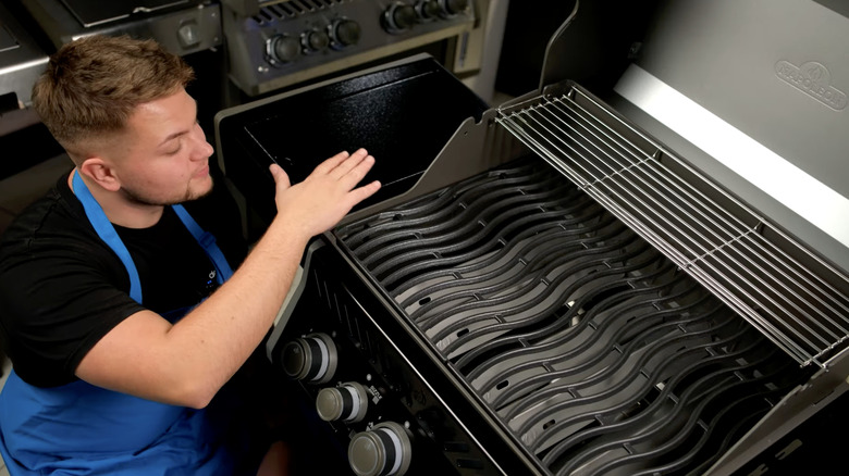 person looking at Napoleon Rogue Pro grill