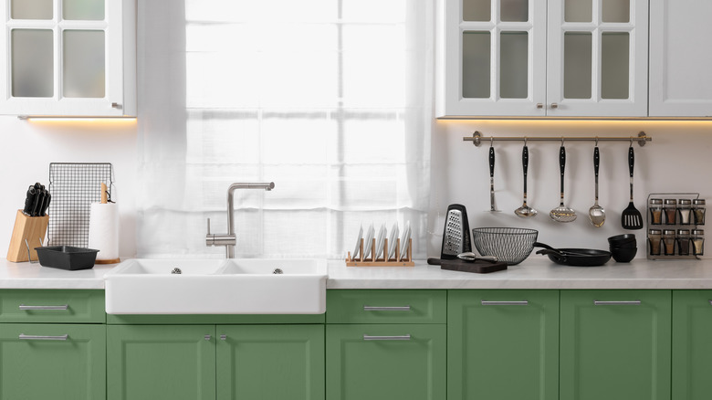 a kitchen counter with bottom cabinets in a saturated sage color