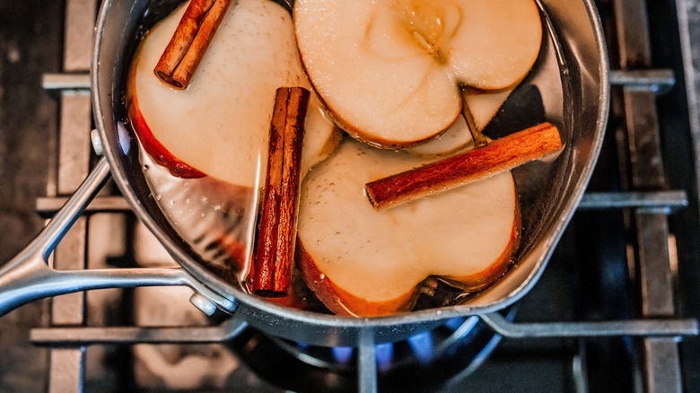 Pot of apples and cinnamon sticks simmering on the stove