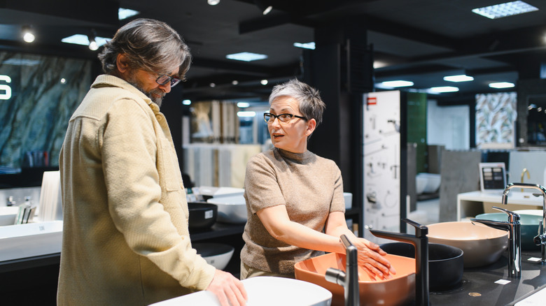Couple looking at various sink options in a store
