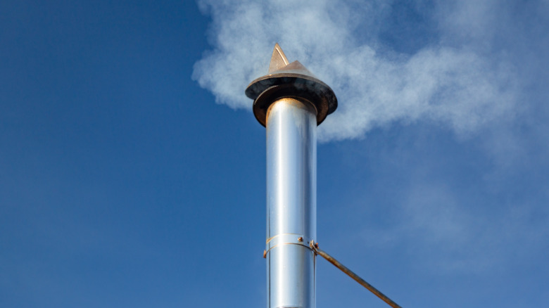 Galvanized chimney pipe above the roofline