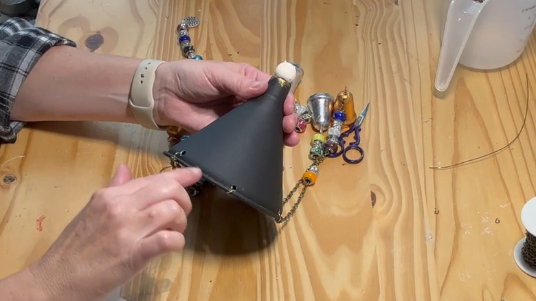 Person putting the finishing touches on the funnel windchimes