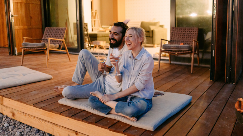 A couple sits outside in the evening, illuminated by soft lights