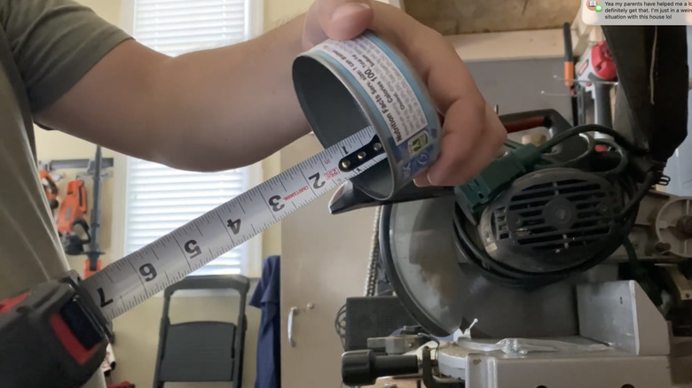 A man measures a tuna can to determine the depth before transforming it into a water measurement device.