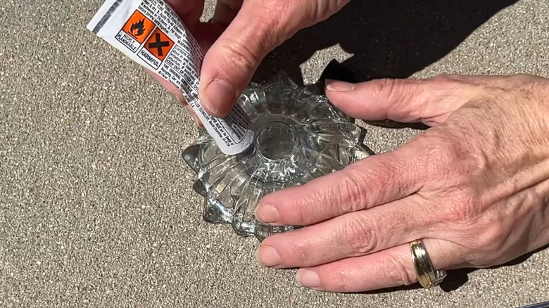 Creator applying glue to a glass piece to create a flower