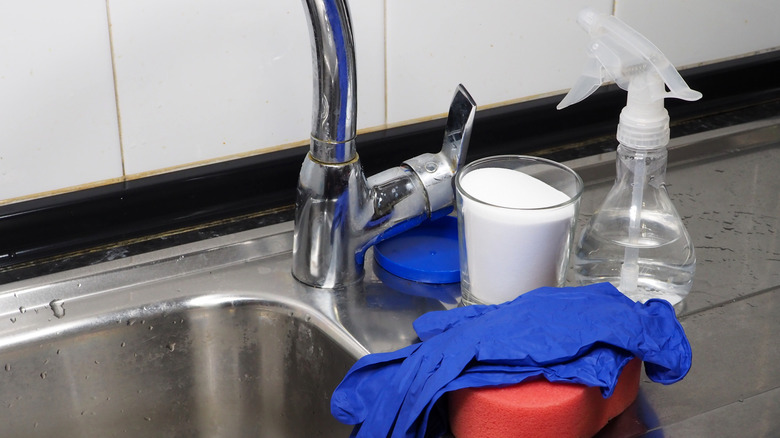 Baking soda in a cup and vinegar in a spray bottle